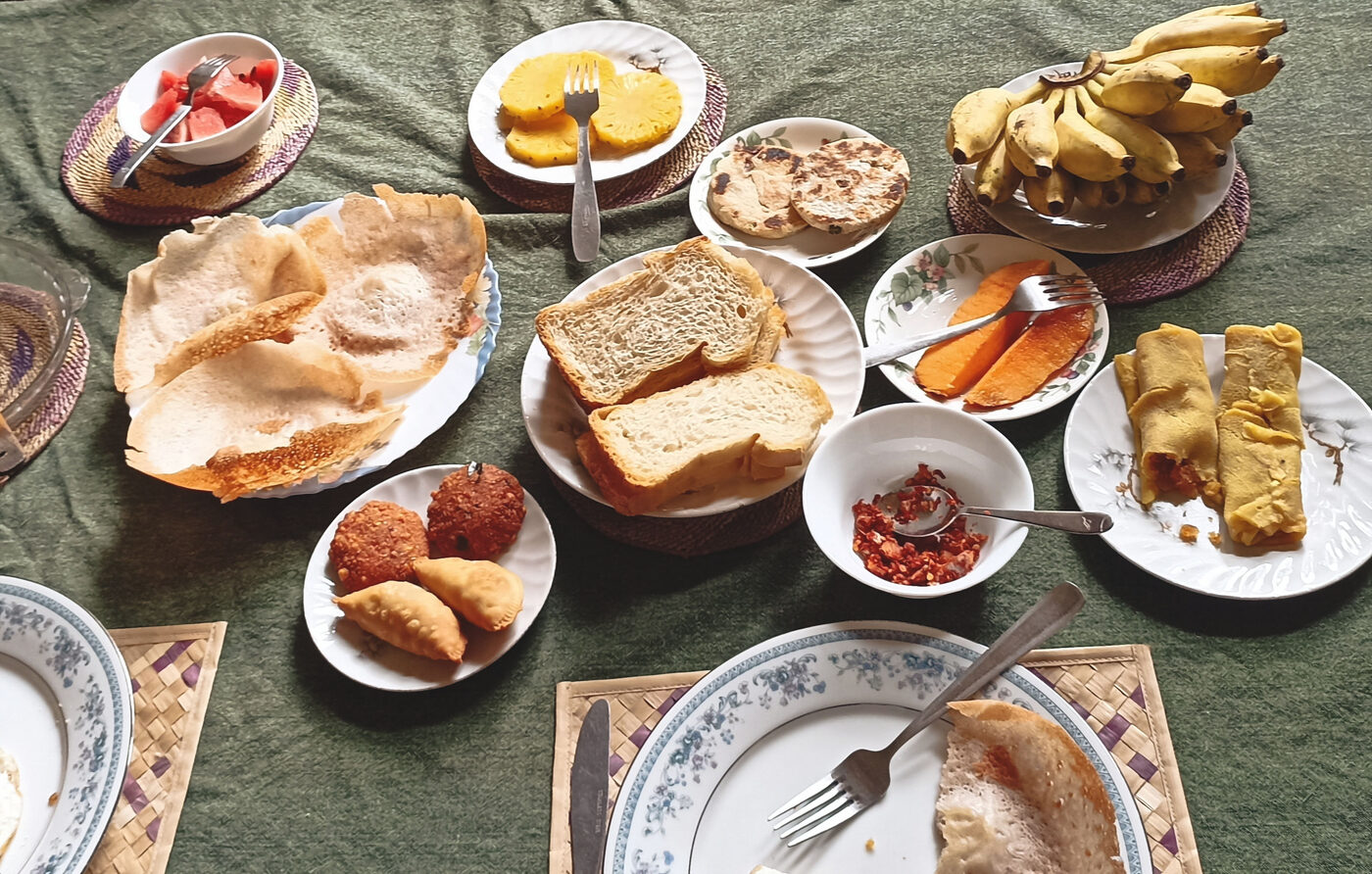 Traditional Sri Lankan breakfast spread with hoppers, fruit and curries