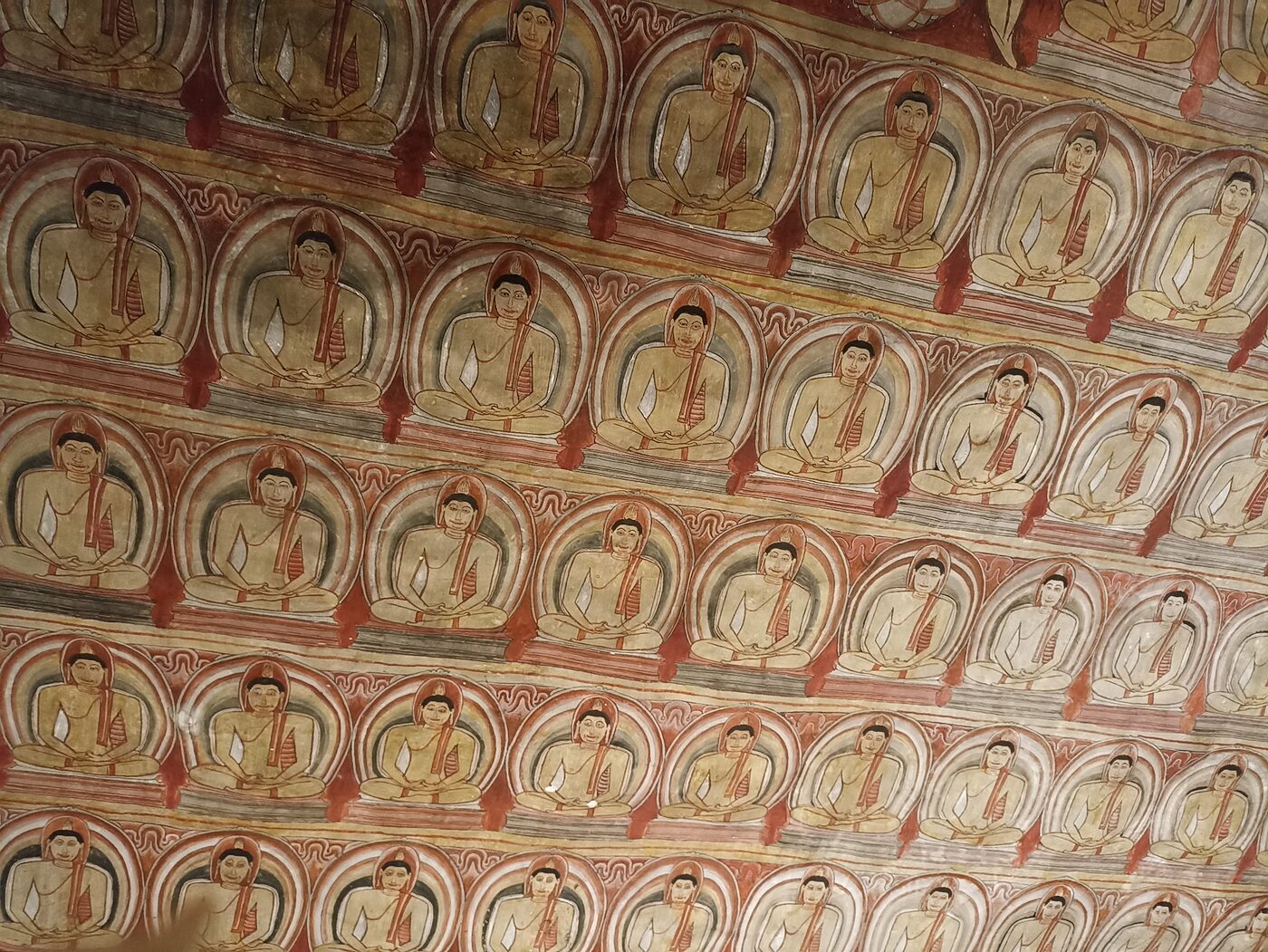 Rows of Buddha murals painted across the Dambulla cave temple ceiling