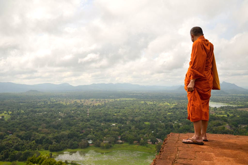 A Buddhist monk taking in the view from a hilltop viewpoint